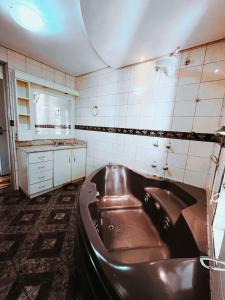 La salle de bains est pourvue d'une baignoire. dans l'établissement Pousada Quinta dos Medeiros, à Canela
