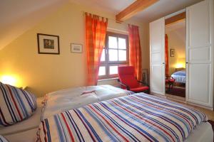 a bedroom with a bed and a red chair at Appartement "Romantika" in Klink