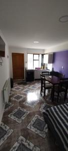 a living room with a table and a kitchen at Departamento Nuevo in Punta Arenas