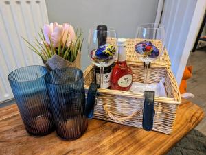 a basket of wine glasses and flowers on a table at Entire Apartment Near Newcastle City Centre, West Jesmond. in Town Moor