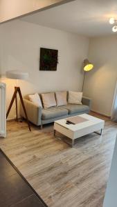 ein Wohnzimmer mit einem Sofa und einem Couchtisch in der Unterkunft L'Edelweiss Campus & Parking privé securisé in Gières