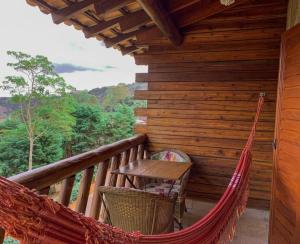 a hammock on the porch of a log cabin at Pousada Peterle in Domingos Martins