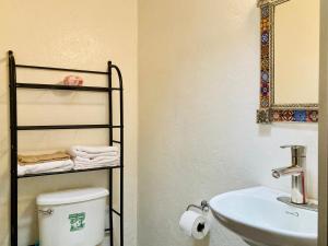 y baño con aseo, lavamanos y estante. en Rincón Coapa, en Ciudad de México