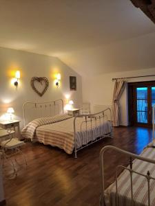 a bedroom with two beds and a heart on the wall at Le Moulin du Fay in Villemotier