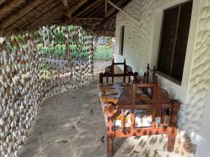 een slaapkamer met 2 bedden en een stenen muur bij Le Grand Forest dreams Resort in Ukunda