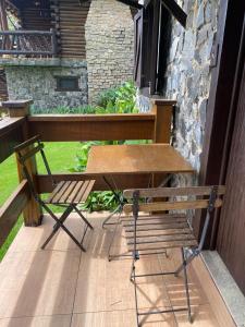 a wooden bench and a table and a chair on a porch at Pousada Peterle in Domingos Martins
