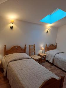 a bedroom with two beds and a blue light at Le Moulin du Fay in Villemotier