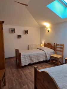 a bedroom with two beds and a skylight at Le Moulin du Fay in Villemotier