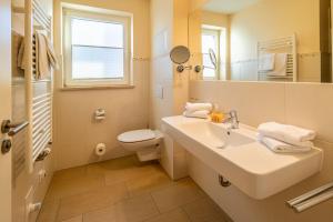 a bathroom with a sink and a toilet and a mirror at Hafendomicil Appartement WH11 - Eichhörnchen in Waren