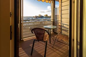 a table and a chair on a balcony with a view at Hafendomicil Appartement WH11 - Eichhörnchen in Waren