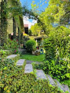 un jardin avec des allées en pierre, des arbres et des plantes dans l'établissement Pousada Quinta dos Medeiros, à Canela