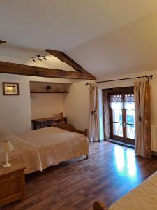 a bedroom with two beds and a wooden floor at Le Moulin du Fay in Villemotier