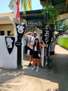 a man and a woman standing in front of a building at Aladdin Homestay in Gili Islands