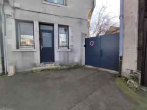 a building with a blue gate in front of it at La petite bascule in Orléans +1 photo