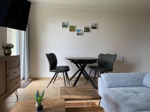 uma sala de estar com uma mesa e cadeiras e um sofá em Haus am Kölpinsee App 4 1 em Kölpinsee