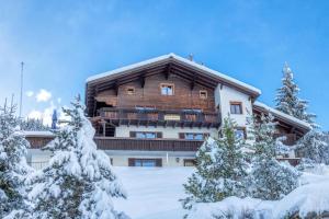a large building with snow covered trees in front of it at Alpinechalet Zigjam in Gaschurn