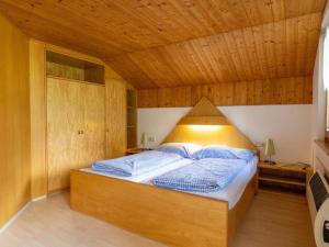 a bed in a room with a wooden ceiling at Alpinechalet Zigjam in Gaschurn