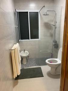 a white bathroom with a toilet and a sink at Brisa da Ribeira in Furnas +26 photos