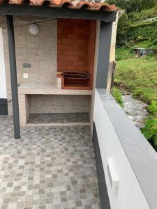 a patio with a bench on the side of a building at Brisa da Ribeira in Furnas