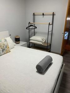 a bed with a gray towel on it with a chair at Brisa da Ribeira in Furnas