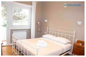 a white bed in a room with a window at Appartamento Executive Home in Lido di Ostia