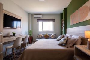 a bedroom with a large bed and a couch at Equipetrol Suites apart hotel in Santa Cruz de la Sierra