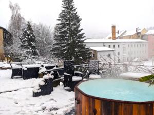 a hot tub in a yard covered in snow at Urlaubsmagie - Wohlfühlwohnung mit Balkon, Pool, Sauna & Terrasse - HW2b in Sebnitz