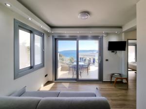 a living room with a couch and a view of the ocean at XENIA LUXURY APARTMENTS CHIOS in Chios