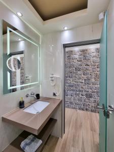 キオスにあるXENIA LUXURY APARTMENTS CHIOSのレンガの壁、洗面台付きのバスルーム