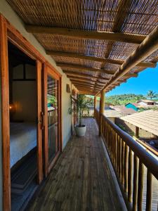 a porch of a house with a wooden deck at Tawa Caraíva in Caraíva