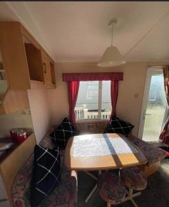 a small caravan with a table and a dining room at Lovely 8 Berth Caravan In Skegness With Free Wi-fi, Ref 96023d in Skegness