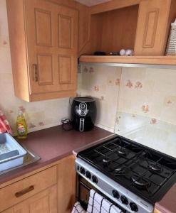 a kitchen with a stove top oven in a kitchen at Lovely 8 Berth Caravan In Skegness With Free Wi-fi, Ref 96023d in Skegness