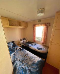 two beds in a small room with a window at Lovely 8 Berth Caravan In Skegness With Free Wi-fi, Ref 96023d in Skegness