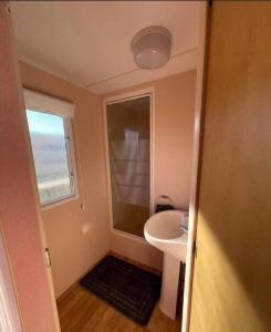 Baño pequeño con lavabo y espejo en Lovely 8 Berth Caravan In Skegness With Free Wi-fi, Ref 96023d, en Skegness