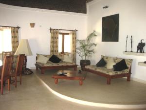 a living room with two couches and a table at Watamu Villa With Service Personnel in Watamu