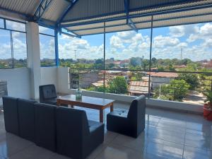 a room with a table and chairs and large windows at Makasai Habitaciones in Puerto Maldonado