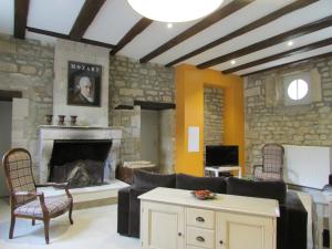 een woonkamer met een bank en een open haard bij Gites de Jeand'Heurs in Lisle-en-Rigault
