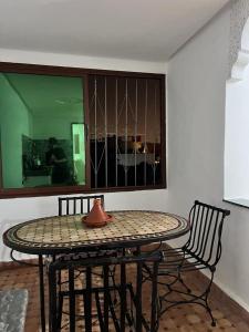 een tafel en 2 stoelen in een woonkamer met een vaas bij Medina Stars in Rabat