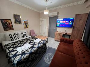 a bedroom with a bed and a couch and a flat screen tv at Royal Suite Hotel in Istanbul