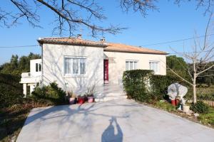 a white house with a red door and a driveway at VILLA BOIS LAUZON in Orange