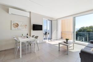 a living room with a white table and chairs at Residence Conca Verde 2 with pool in Trarego Viggiona