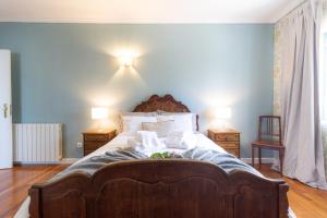 een slaapkamer met een groot houten bed met 2 lampen bij Quinta Moinhos da Tapada in Luso
