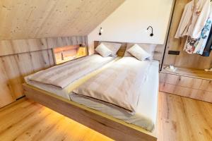 a large bed in a room with wooden floors at Luxury Resort Potatoland in Šenčur