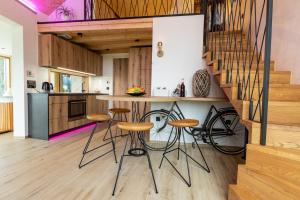 a kitchen with a bar with stools and a staircase at Luxury Resort Potatoland in Šenčur