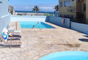 舊巴拉的住宿－Frente Mar Praia do Tabuleiro - Condomínio Costa Esmeralda，游泳池,有水中的人