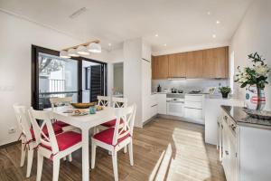 a kitchen and dining room with a white table and chairs at PEAR TREE VILLA in Vale do Lobo
