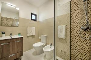 a bathroom with a toilet and a sink and a shower at PEAR TREE VILLA in Vale do Lobo