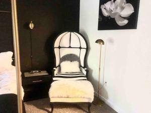 a black and white chair in a bedroom with a mirror at Savannah Posh 2 King Bed townhome near downtown and Tybee in Savannah