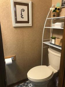 a bathroom with a white toilet and a shelf at Savannah Posh 2 King Bed townhome near downtown and Tybee in Savannah