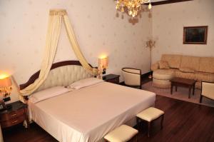 een slaapkamer met een groot bed en een bank bij Hotel Borgo Don Chisciotte in Modica